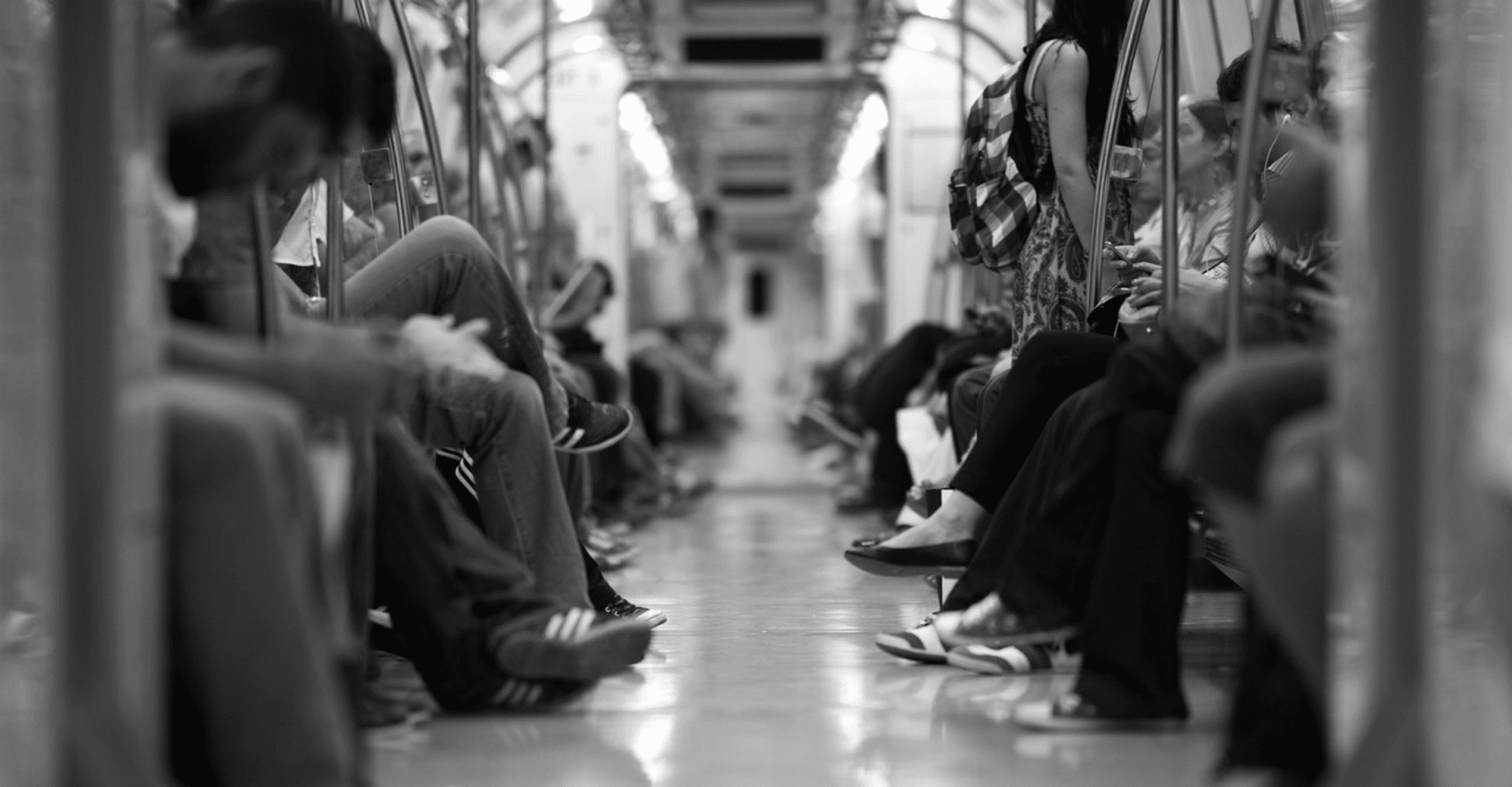Czarno-białe zdjęcie przedstawiające ludzi w metrze.