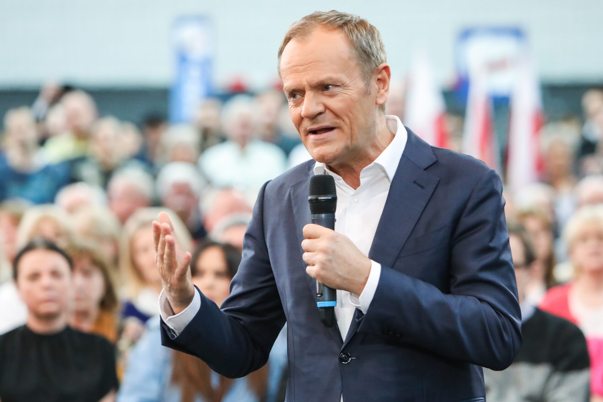 Donald Tusk z mikrofonem, w tle tłum