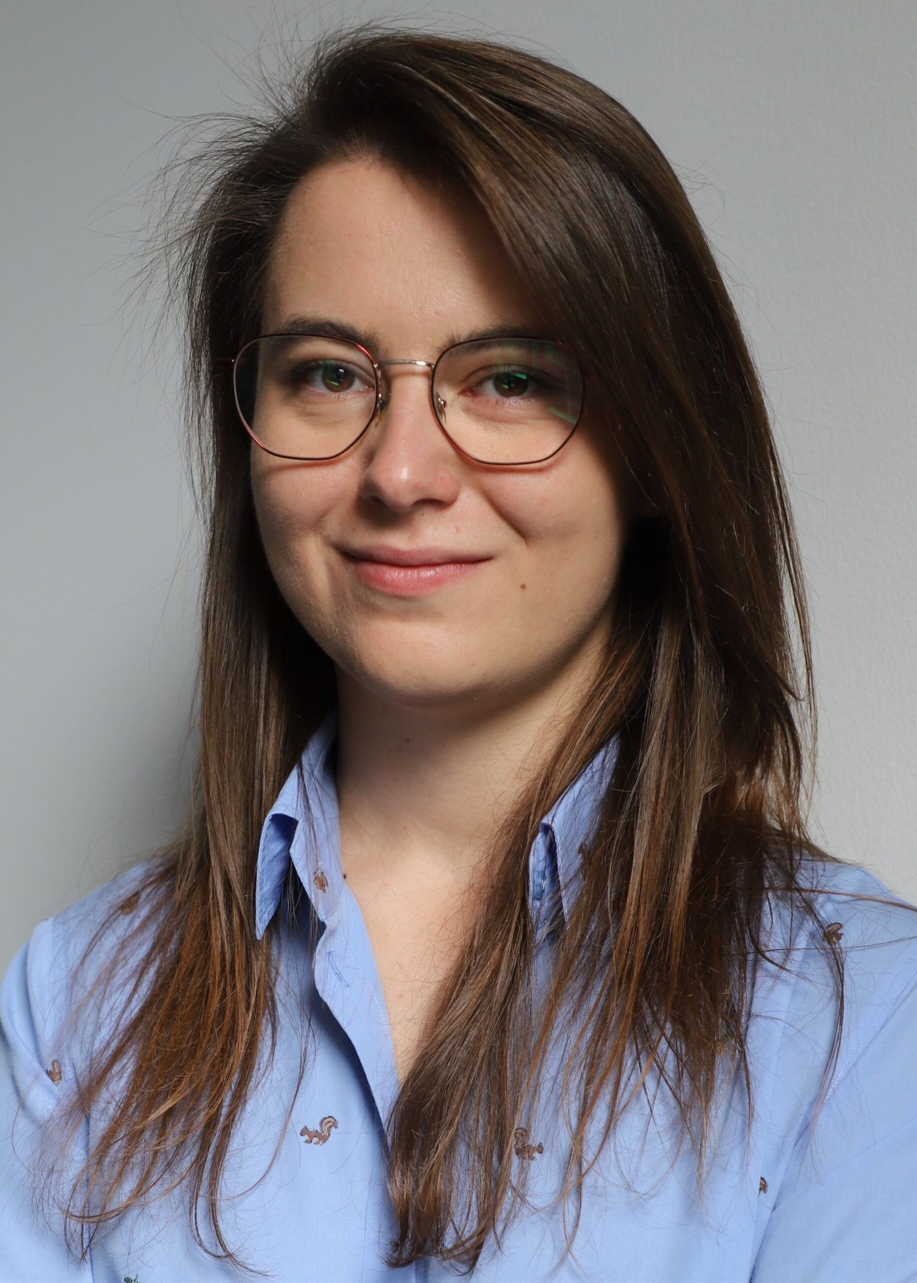 Fotograficzny portret Moniki Stachoń w koszuli na jednolitym tle