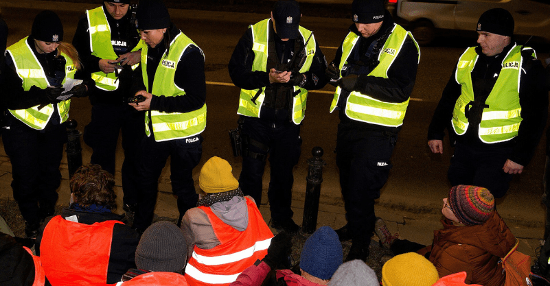 Policjanci sprawdzający tożsamość protestujących