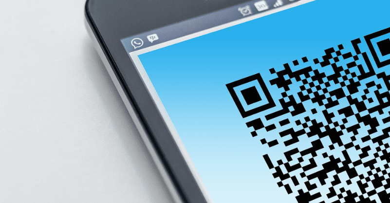 telefon z kodem qr położony na stole