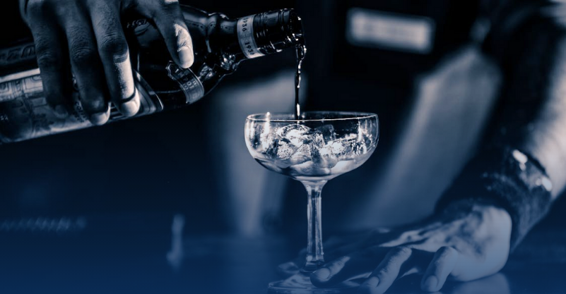 w tle kieliszek i butelka z alkoholem