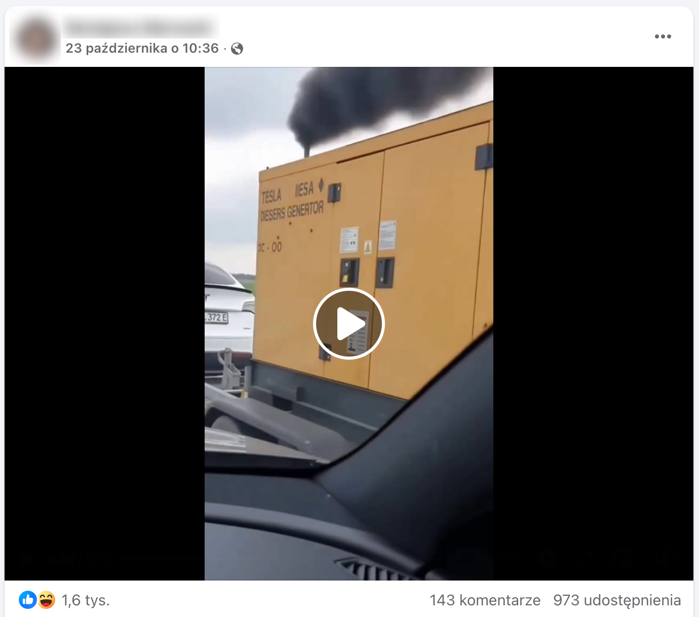 Zrzut ekranu posta na Facebooku. W kadrze filmu znajduje się przyczepa z żółtym generatorem doczepiona do białej Tesli. Z komina wydobywają się spaliny.