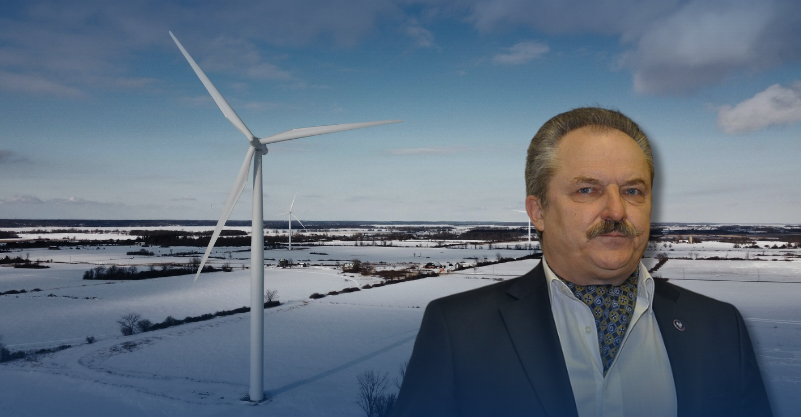Marek Jakubiak na tle wiatraków zimą