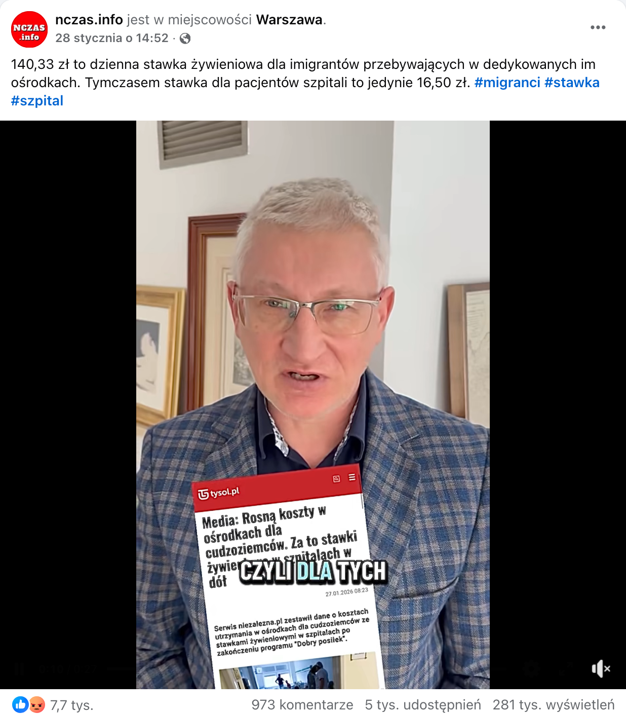 Zrzut ekranu przedstawiający post opublikowany na Facebooku. Do wpisu dołączono nagranie, na którym widać mężczyznę ubranego w marynarkę w kratę i srebrne okulary. Przed nim widać zrzut ekranu internetowego artykułu pt.: Media: Rosną koszty w ośrodkach dla cudzoziemców. Za to stawki żywieniowe w szpitalach w dół.